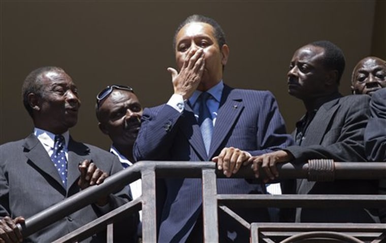 Haiti's former dictator Jean-Claude 'Baby Doc' Duvalier, center, gestures to supporters on the balcony of his hotel room in Port-au-Prince, Haiti, on Wednesday.